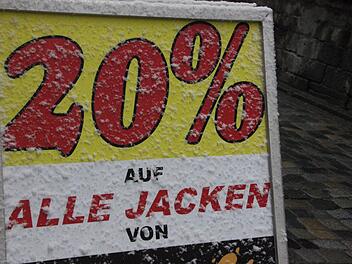 Der so genannte "Kundenstopper", ein Werbeaufsteller vor dem Geschäft, ist verschneit, aber trotzdem gibt's schon satte 20 Prozent auf Jacken einer bekannten Marke. Foto: Friedwald Schedel