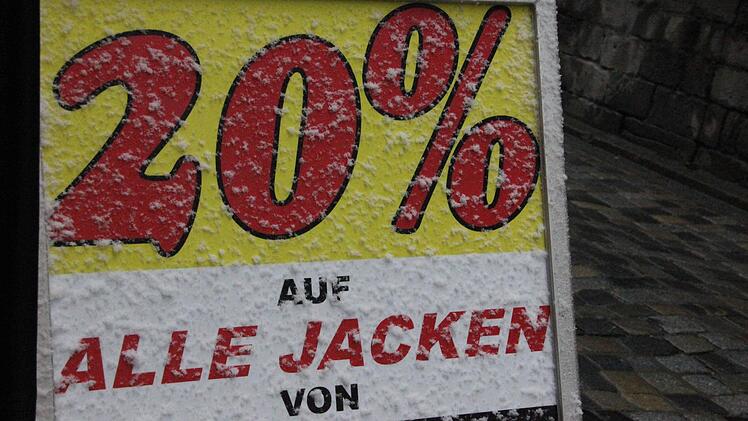 Der so genannte "Kundenstopper", ein Werbeaufsteller vor dem Geschäft, ist verschneit, aber trotzdem gibt's schon satte 20 Prozent auf Jacken einer bekannten Marke. Foto: Friedwald Schedel