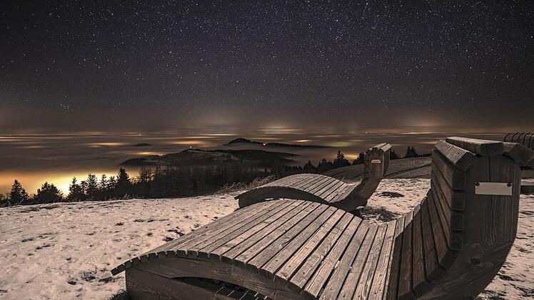 In seinem Rhön-Kalender "Rhönheimat 2021" präsentiert Jürgen  Hüfner jahreszeitliche Impressionen aus dem "Land der Offenen Fernen".  Hier die Ruhebänke auf der Wasserkuppe bei nächtlichem Hochnebel und Sternenmeer.  Foto: Jürgen Hüfner