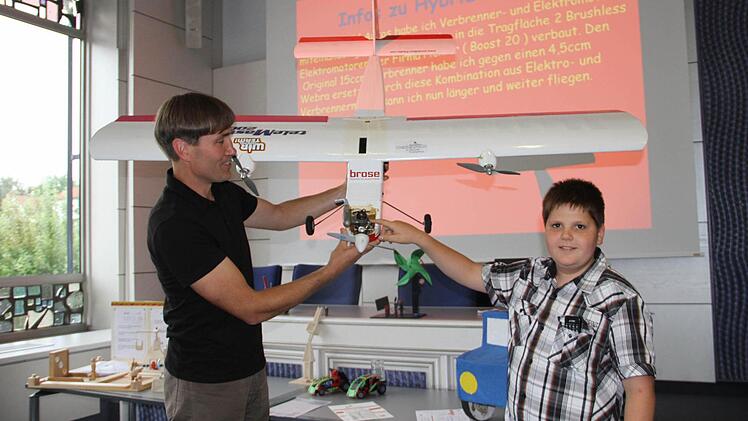 Wie bei den Hybrid-Autos hat Hendrik Schmitt bei seinem Flieger Verbrenner- und Elektromotor miteinander gekoppelt. Mit im Bild ist Jurymitglied Michael Stromer (links).  Foto: Gerda Völk