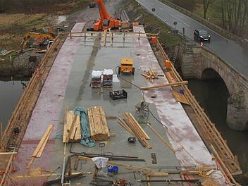 11,60 Meter breit ist die neue Rotmainbrücke. Die alte Sandsteinbrücke (rechts), über die der Verkehr noch bis Mitte nächsten Jahres fließt, wirkt mit ihren 5,60 Metern Breite im Vergleich dazu geradezu mickrig. Fotos: Alexander Hartmann