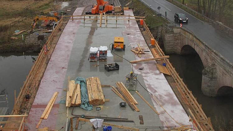 11,60 Meter breit ist die neue Rotmainbrücke. Die alte Sandsteinbrücke (rechts), über die der Verkehr noch bis Mitte nächsten Jahres fließt, wirkt mit ihren 5,60 Metern Breite im Vergleich dazu geradezu mickrig. Fotos: Alexander Hartmann