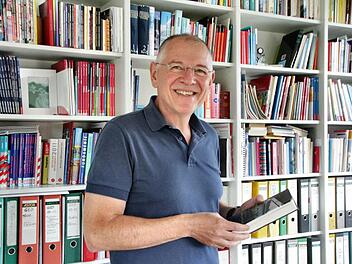 Karl Waldmann mit Lieblingsbuch (Nachtzug nach Lissabon) an seinem Lieblingsort: in der eigenen Bibliothek daheim in Heroldsbach im Öko-Haus direkt am Waldrand. Fotos: Nikolas Pelke