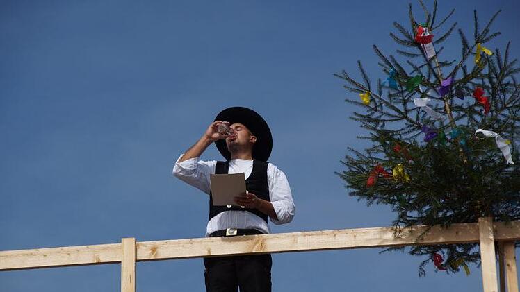 Zimmermeister Marcel Keßler verkündete oben auf dem Dach den Richtspruch für das neue Gebäude, leerte das Glas mit Wein dreimal und warf es dann nach alter Sitte mit Schwung in die Tiefe, denn Scherben sollen Glück bringen.