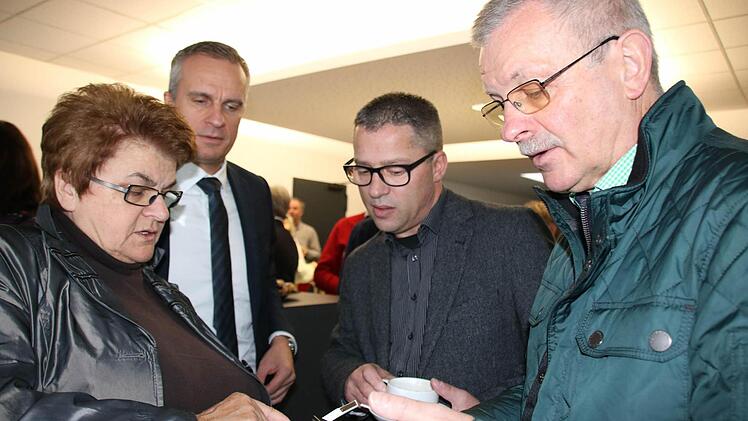 Geschäftsführer Alexander Subat (hinten, links) schaute bei der Bad Kissinger Stadträtin Martha Müller (links) und Bürgermeister Gotthard Schlereth (rechts) nüber die Schulter, als sie die App installierten. Steffen Höffler (hinten rechts) nutzt sie schon länger. Foto: Ralf Ruppert