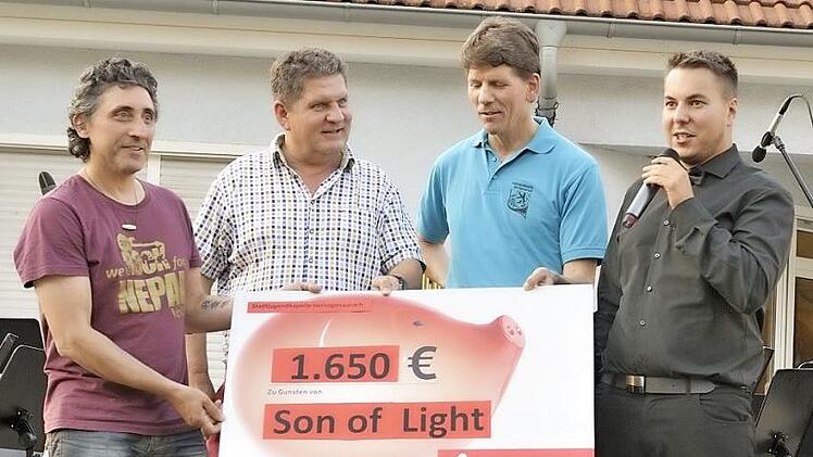 Alberto Parmigiani nahm die Spende aus den Händen von Rainer Wanjelik (Dirigent der Ehemaligen der Stadtjugendkapelle), Wolfgang Niewelt (Präsident Stadtjugendkapelle) und Tobias Komann (Vizepräsident der Stadtjugendkapelle, v. l.) entgegen.  Foto: Meschede
