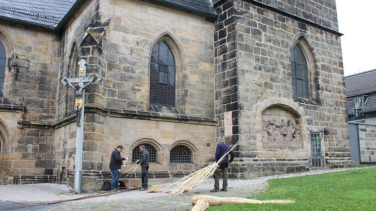 Manfred Rauh vom Verein ZEF (links) schaut zum Projekt-Beginn bei den Flechtern an der Kirche vorbei. Er hat das Flechtmaterial (geschälte Weide und zur Stabilisierung lange Haselnussstöcke) organisiert. Foto: Pop