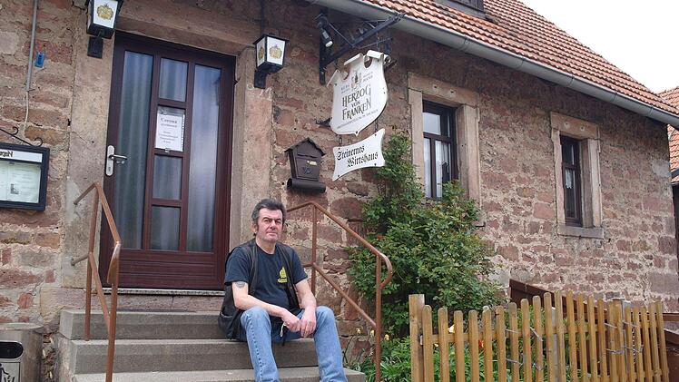 Hannes Petzsch vor der verschlossenen Tür des Steinernen Wirtshauses in Weißenbach. Wann er diese für Gäste wieder öffnen können, weiß er auch jetzt noch nicht. Foto: Stephanie Elm