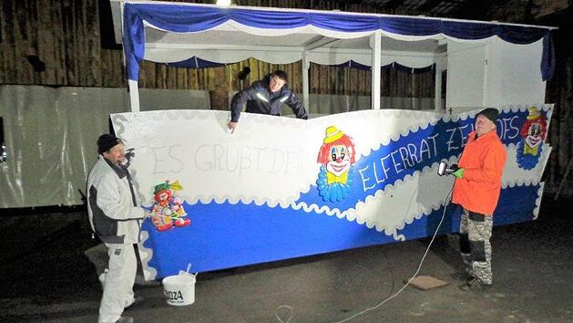 Bei Dunkelheit ist Improvisationstalent gefragt. Klaus Diller (rechts) sorgt f&uuml;r die provisorische Beleuchtung, Matthias Hauke (Mitte) koordiniert den Arbeitsablauf, und Thomas H&ouml;fler (links) k&uuml;mmert sich um den Anstrich am Zeitlofser Elferratswagen. Foto: Rolf Pralle