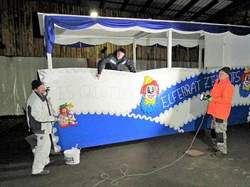 Bei Dunkelheit ist Improvisationstalent gefragt. Klaus Diller (rechts) sorgt für die provisorische Beleuchtung, Matthias Hauke (Mitte) koordiniert den Arbeitsablauf, und Thomas Höfler (links) kümmert sich um den Anstrich am Zeitlofser Elferratswagen. Foto: Rolf Pralle