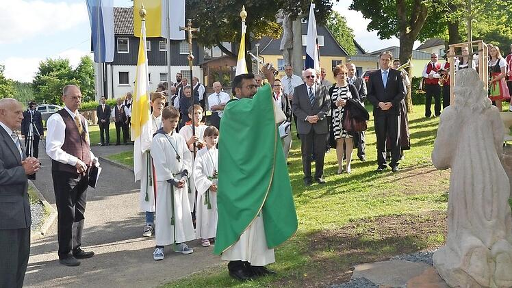 Pfarrer Cyriak Chittukalam segnet die renovierte steinerne Skulptur "Betender Jesus am Ölberg" (rechts) auf dem Friedhof in Windheim. In der Mitte von rechts, Schirmherr Landrat Klaus Löffler, Bürgermeister Thomas Löffler, Michaela Mattes (stellvertretende Vorsitzende Sängerkreis Coburg-Kronach-Lichtenfels), Günter Künzel (Gemeinderat). Zweiter von links Manfred Fehn daneben links Wendelin Vetter (OGV Windheim) Foto: K.-H. Hofmann