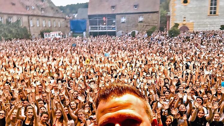 So erleben die Stars die Fanschar in einem mit 4500 Zuschauern ausverkauften Schlosshof von Eyrichshof. Jörg Wagner von Radio Bamberg, der die Anmoderation übernahm, knipste dieses Selfie vor überwältigender Kulisse bei der Anmoderation des Auftritts von Wincent Weiss im Jahr 2019.