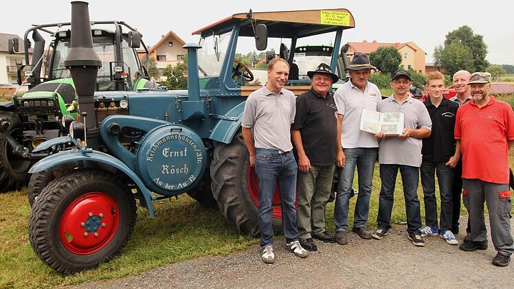 Auf großes Interesse mit seiner Geschichte und seinen Bilddokumenten über seinen Lanz 8506 stieß Ernst Rösch (Dritter von links) bei Vorstand Artur Graser (Vierte von links) und interessierten Besuchern.