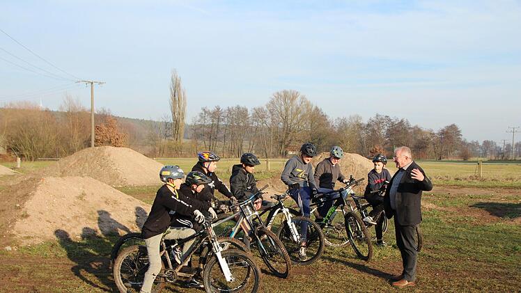 Bürgermeister Gleitsmann (rechts) erklärt den jungen Bikern,  für sie ein neues Gelände  suchen zu müssen.  Foto: Andreas Dorsch