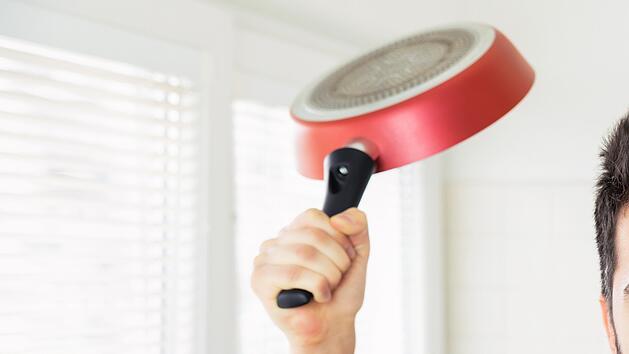 Mann droht in K&uuml;che mit Bratpfanne in der Hand