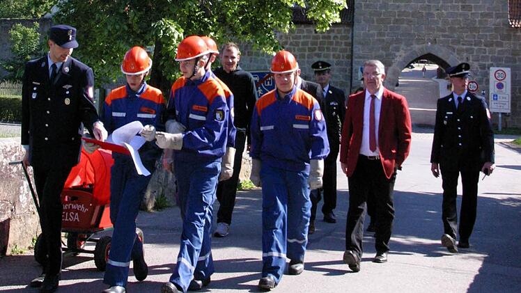 Begleitet von Landrat Michael Busch (2. v. rechts), Kreisbrandrat Manfred Lorenz (verdeckt), Kreisjugendwart Stefan Wunder (rechts) und Seßlachs Bürgermeister Martin Mittag (hinten links) nahm die Jugendgruppe aus Elsa als erste den Wettkampf über elf Stationen zwischen Seßlach und Hattersdorf auf.Foto: Bettina Knauth