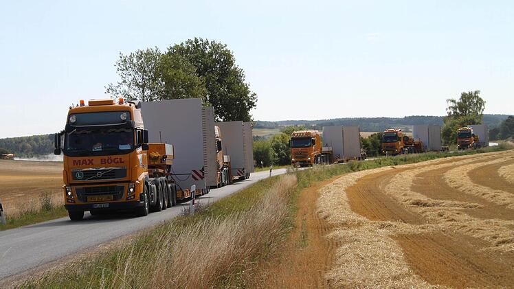 Die Tieflader fahren auf der Verbindungsstraße Alladorf-Kleinhül in einer Kolonne zum Windpark-Areal.