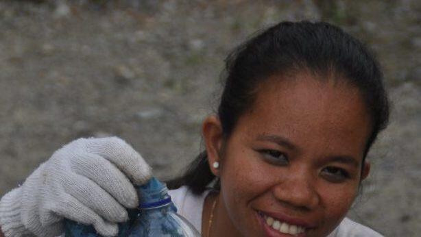 Eine junge Indonesierin stopft Plastikmüll in eine Flasche. So entsteht ein Eco-Brick. Keilholz