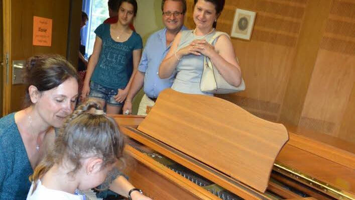 Großes Interesse bestand beim "Tag der offenen Tür" am Klavier. Hier darf die sechsjährige Katharina Beetz erste Töne auf der Tastatur spielen, geführt von Musiklehrerin Yvonne Preising. Foto: K.-H. Hofmann