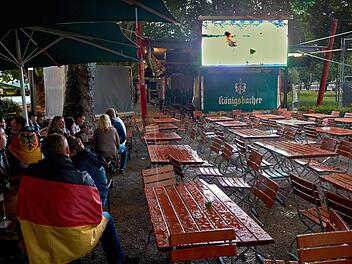 Public Viewing im Jahr 2022? Fußballfans sitzen in einem Biergarten, Der Sonnenschirm dient allein dem Regenschutz. Foto: Thomas Frey/dpa