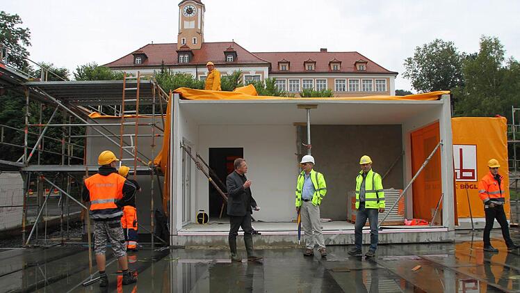 Die ersten Module des Kindergartens sind montiert. OB Henry Schramm, Bernd Ohnemüller und Hartmut Arndt vom Hochbauamt waren bei der Anlieferung per Kran dabei. Foto: Dagmar Besand