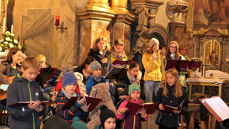 Fröhliches Gewimmel vor dem Altar: Sänger aller Altersgruppen üben eifrig für das Konzert.