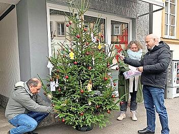Alexander Schmidt, Alexandra Preisigker und Michael Kastl (von links) hängen die Wunschzettel an den Baum.