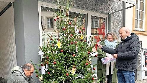Alexander Schmidt, Alexandra Preisigker und Michael Kastl (von links) hängen die Wunschzettel an den Baum.