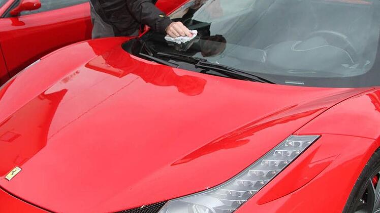 Ein bisschen Pflege muss sein: Michael Becker aus Erlangen säubert schnell noch vor der Einkehr sein nagelneues Ferrari-Schätzchen mit Hardtop, denn Fliegenmatsch auf der Scheibe sieht nun einmal nicht gut aus.