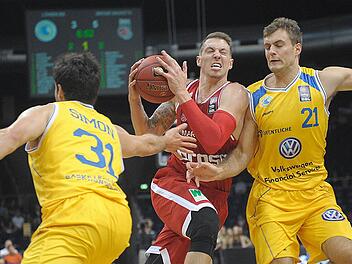 Der Bamberger Daniel Theis (M) setzt sich gegen die Braunschweiger Nicolai Simon (l) und Tim Abromaitis (r) durch. Foto: Dominique Leppin/dpa