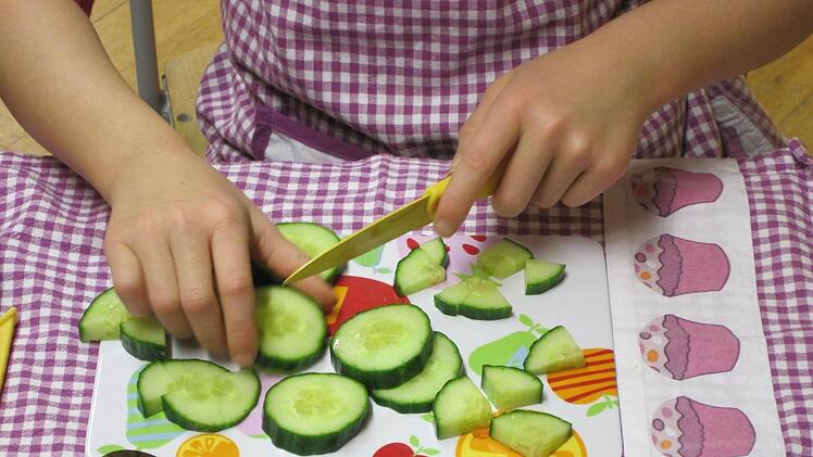 Eine Schülerin schneidet eine Salatgurke. Foto: privat