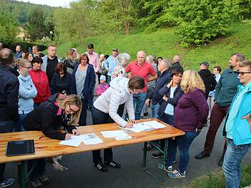 Mit ihrer Unterschrift protestieren die Anwohner gegen das Bauvorhaben. Rechts Kerstin Kreiner-Bischoff, die das Treffen initiiert hatte, links neben ihr Karlheinz Vollrath, Vorsitzender der Kreisgruppe Kulmbach imBund Naturschutz.Foto: Katrin Geyer