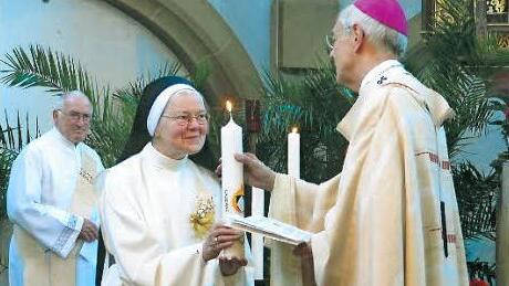 "Seien Sie das Licht Christi!": Erzbischof Ludwig Schick überreicht Schwester Berthilla eine Kerze.  Foto: Bärbel Meister