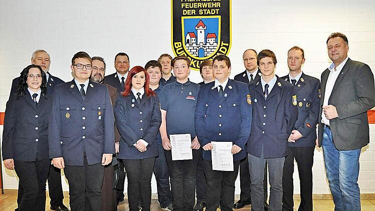 Stolz nahmen die Anw&auml;rter Max Konrad (Dritter von links), Celina Pechtold, Felix Rank, Tim Walder, Christian Greich, Peter Nikolay, Christoph Berthold, Leon Wolf ihre Abzeichen entgegen. Es gratulierten (von links) Jugendwartin Kristina Gro&szlig;, Vorsitzender Walter Petterich, Pater Kosma Rejmer (Vierter von links), stellvertretender Kommandant Michael Kannengie&szlig;er (F&uuml;nfter von links), Dritter B&uuml;rgermeister Manfred Hofmann (rechts), Kommandant Andr&eacute; Grothues (Zweiter von rechts) und Kreisbrandmei...