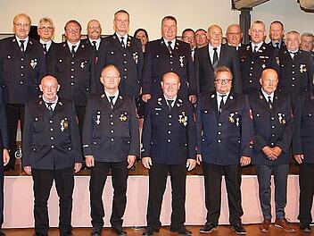 Landrat Christian Mei&szlig;ner (v. li.) sowie Kreisbrandrat Timm Vogler und B&uuml;rgermeister Andreas H&uuml;gerich (vorne v. re.) begl&uuml;ckw&uuml;nschten 22 Feuerwehrm&auml;nner zur Auszeichnung mit dem Feuerwehr-Ehrenzeichen in Gold f&uuml;r 40-j&auml;hrige Dienstzeit.