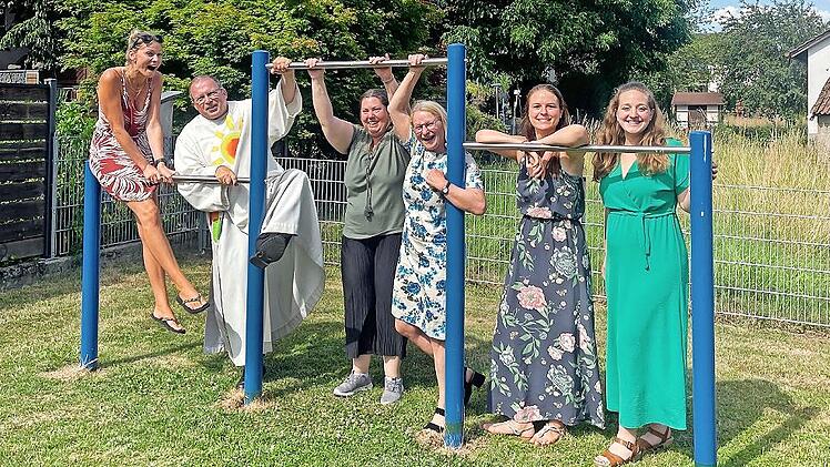 Diakon Manfred M&uuml;ller und zweite B&uuml;rgermeisterin Elisabeth Assmann zusammen mit dem Orga-Team bei der Spielplatzsegnung im Juni 2025 mit dem neu angeschafften Reck