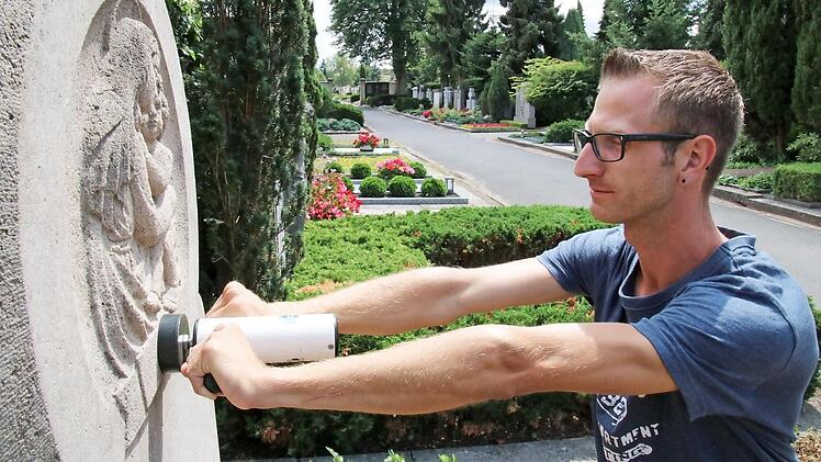 Friedhofsmitarbeiter Daniel Reheuser überprüft die Stabilität des Grabsteines mit dem Drucksensor. Das im Volksmund auch "Rüttelgerät" genannte Messinstrument piept bei einem Druck von genau 500 Newton - etwa 50 Kilogramm. Wenn sich der Stein bewegt, wird er beanstandet.  Fotos: Sebastian Schanz