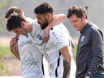 Es droht ein monatelanger Ausfall: Ohne Fremdeinwirkung hat sich Felix Popp beim 6:3-Sieg des FC Eintracht Bamberg beim SC Großschwarzenlohe schwer am Knie verletzt. Seine Mannschaftskollegen Maximilian Vetter und Tobias Ulbricht helfen ihm vom Platz. Sportfoto Zink