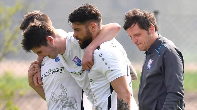 Es droht ein monatelanger Ausfall: Ohne Fremdeinwirkung hat sich Felix Popp beim 6:3-Sieg des FC Eintracht Bamberg beim SC Großschwarzenlohe schwer am Knie verletzt. Seine Mannschaftskollegen Maximilian Vetter und Tobias Ulbricht helfen ihm vom Platz. Sportfoto Zink