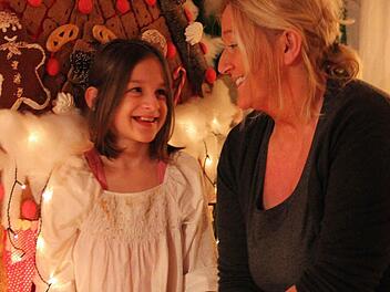 Heidi Sommer mit ihrer jüngsten Tochter Celina mitten in ihrer Weihnachtsdeko vor dem Hexenhaus. Im Wohnzimmer der Familie sieht es aus wie in einer anderen Welt. Foto: Katharina Müller-Sanke