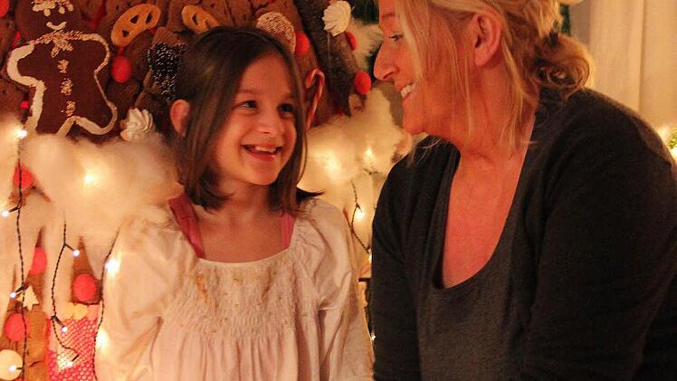 Heidi Sommer mit ihrer jüngsten Tochter Celina mitten in ihrer Weihnachtsdeko vor dem Hexenhaus. Im Wohnzimmer der Familie sieht es aus wie in einer anderen Welt. Foto: Katharina Müller-Sanke