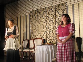 Cordula Kerling (Großmutter und Untersteuereinnehmerinswitwe Staar) sowie Petra Konrad (ihre Enkelin Sabine Staar) auf der Bühne in St. Lukas. Foto: Martin Koch