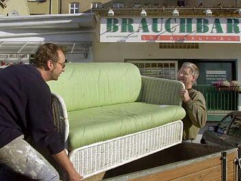 Zwei "Schnäppchenjäger" laden vor dem Würzburger Sozialkaufhaus "Brauchbar", ein von ihnen erstandenes Sofa auf einen Anhänger zum Abtransport. Symbolfoto: Karl-Josef Hildenbrand dpa/lby