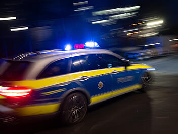 Ein Polizeiauto fährt mit Blaulicht zum Einsatz.
