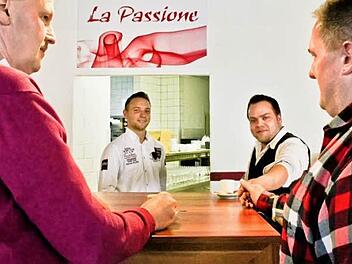 Gerald Brehm (l.) und Sportzentrum-Betriebsleiter Hans-Peter Philipp (r.) trinken einen Espresso im "La Passione". So heißt das Freibad-Restaurant von Konstantin Kussberger und Christian Seegerer (2. v.r.). Foto: S.Martin