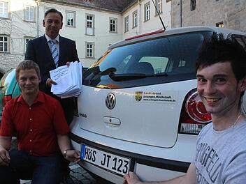 Jochen Tohol (l.) und Johannes Denzler führen im Höchstadter Schlosshof schon mal vor, wie sich ein Auto mit HÖS-Kennzeichen machen würde. Landrat Alexander Tritthart hat von ihnen gerade 1392 Unterschriften dafür bekommen. Foto: Waltraud Enkert