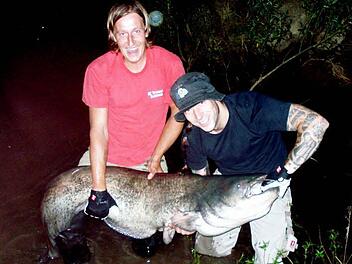 Der glückliche Jungangler Andreas Hofmann (rechts) mit dem Waller, der vier Zentimeter größer ist als er selbst. Rolf Laubmeister musste ihm behilflich sein, um den Fang an Land zu ziehen.  Foto: ab