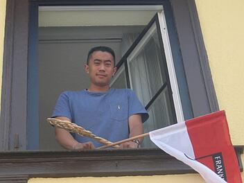 Für den Fränkischen Tag lehnte sich Anthony Ith gerne etwas aus dem Fenster. Mit Frankenfahne und Teppichklopfer. Von "seinem" Büro aus hat er Blick auf den Marktplatz und das Rathaus. Foto: Markus Häggberg