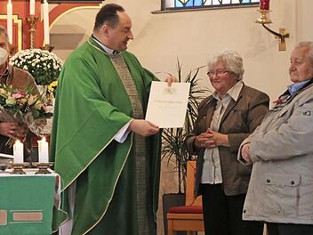 Monsignore Rüdiger Feulner ehrte Klara Heinisch; mit im Bild Kirchengemeinderatsvorsitzender Norbert Herrmann (rechts) und Kirchenpfleger Reinhard Baar (links).  Foto: Klaus Klaschka