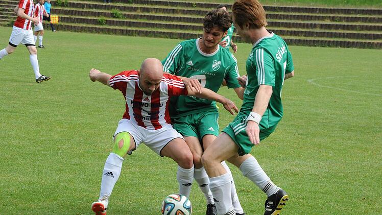 Engagierter Abschied: Gemeinsam machen sich die Garitzer Benedikt Lang und Jens Niebling (rechts) an die Balleroberung gegen Dampfachs Alexander Prichodko. Foto: Hopf